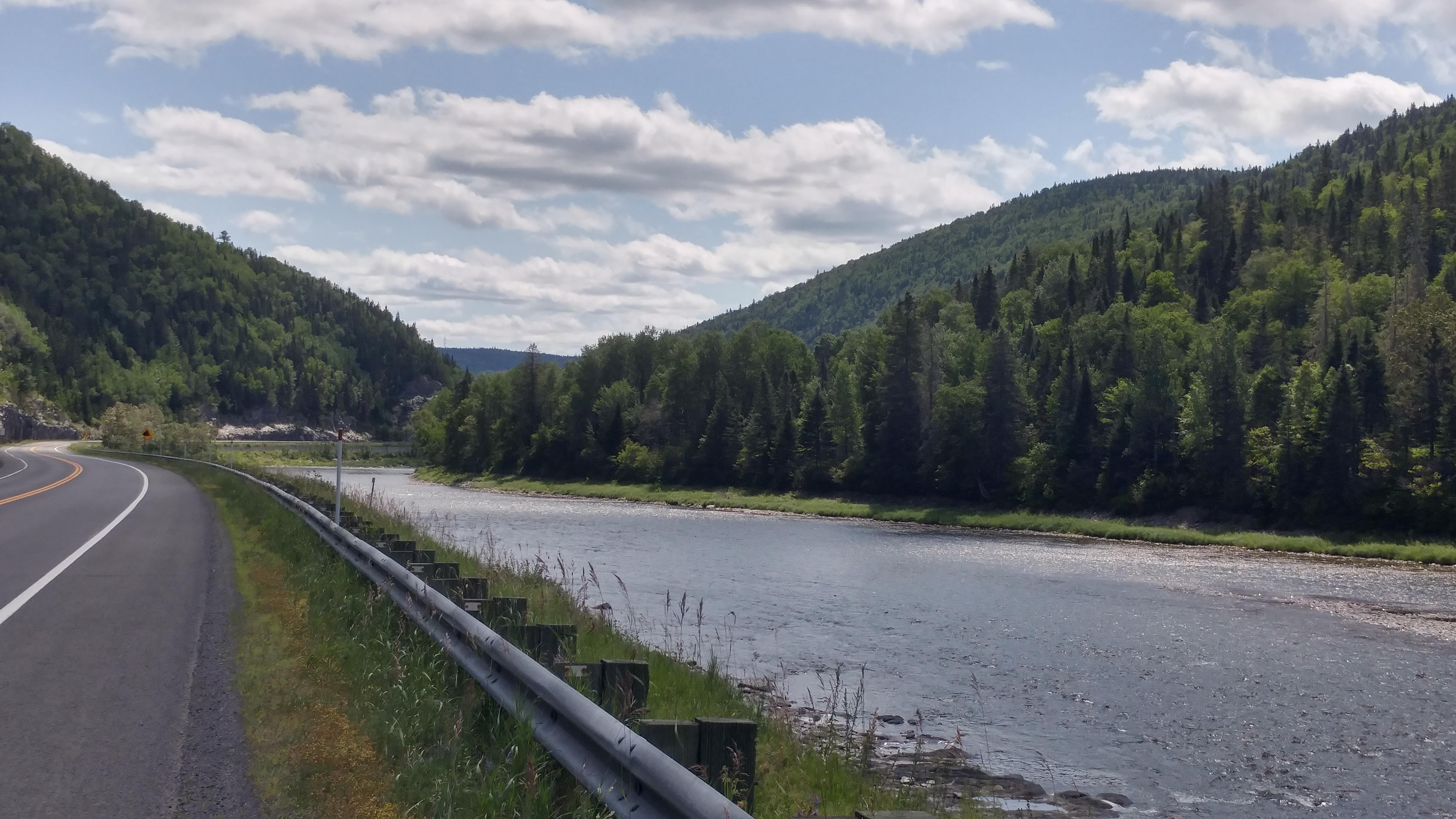 montagnes des deux côtés, route et rivière au milieu