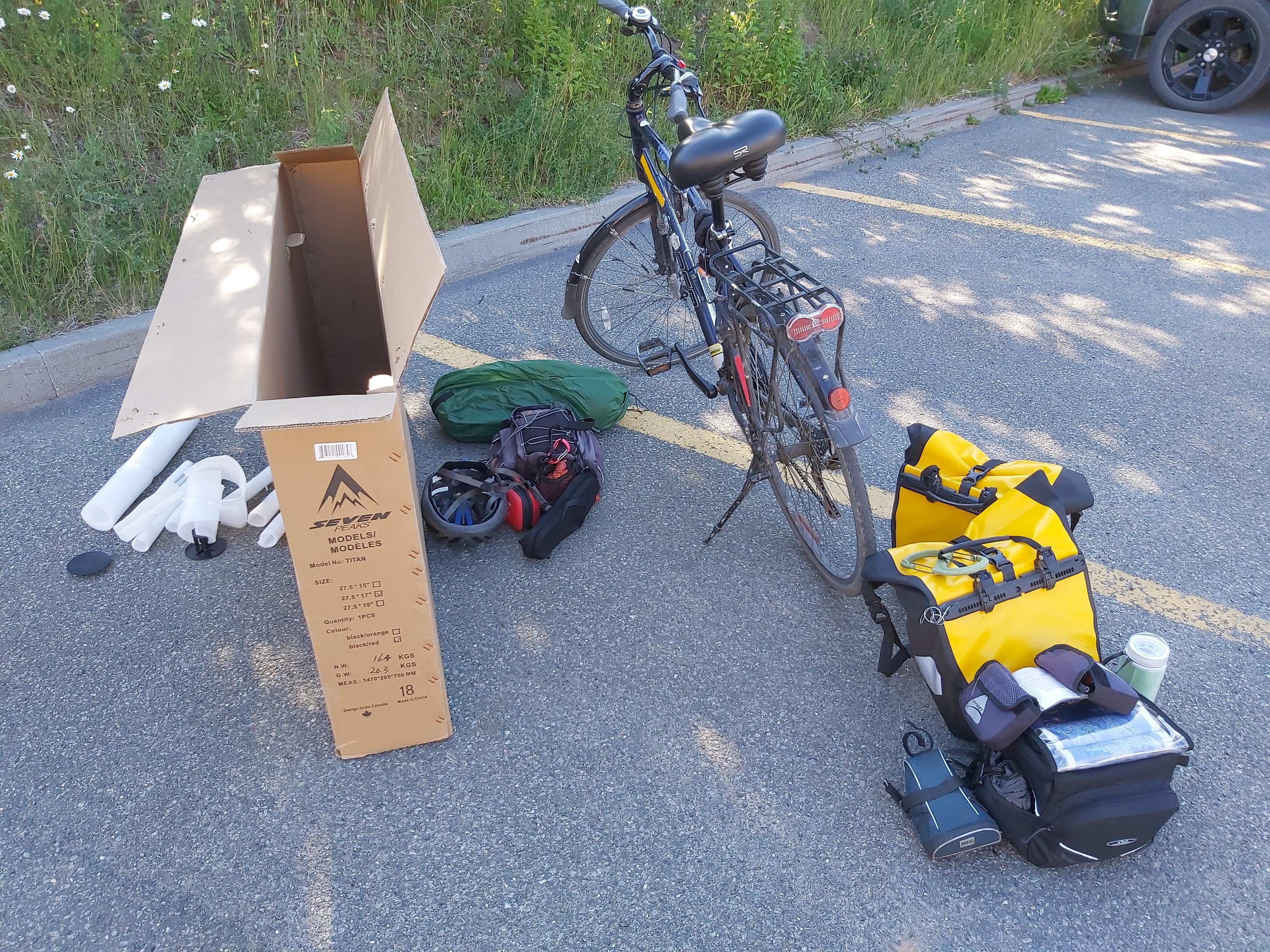 boite vide, vélo et sacoches dans un stationnement