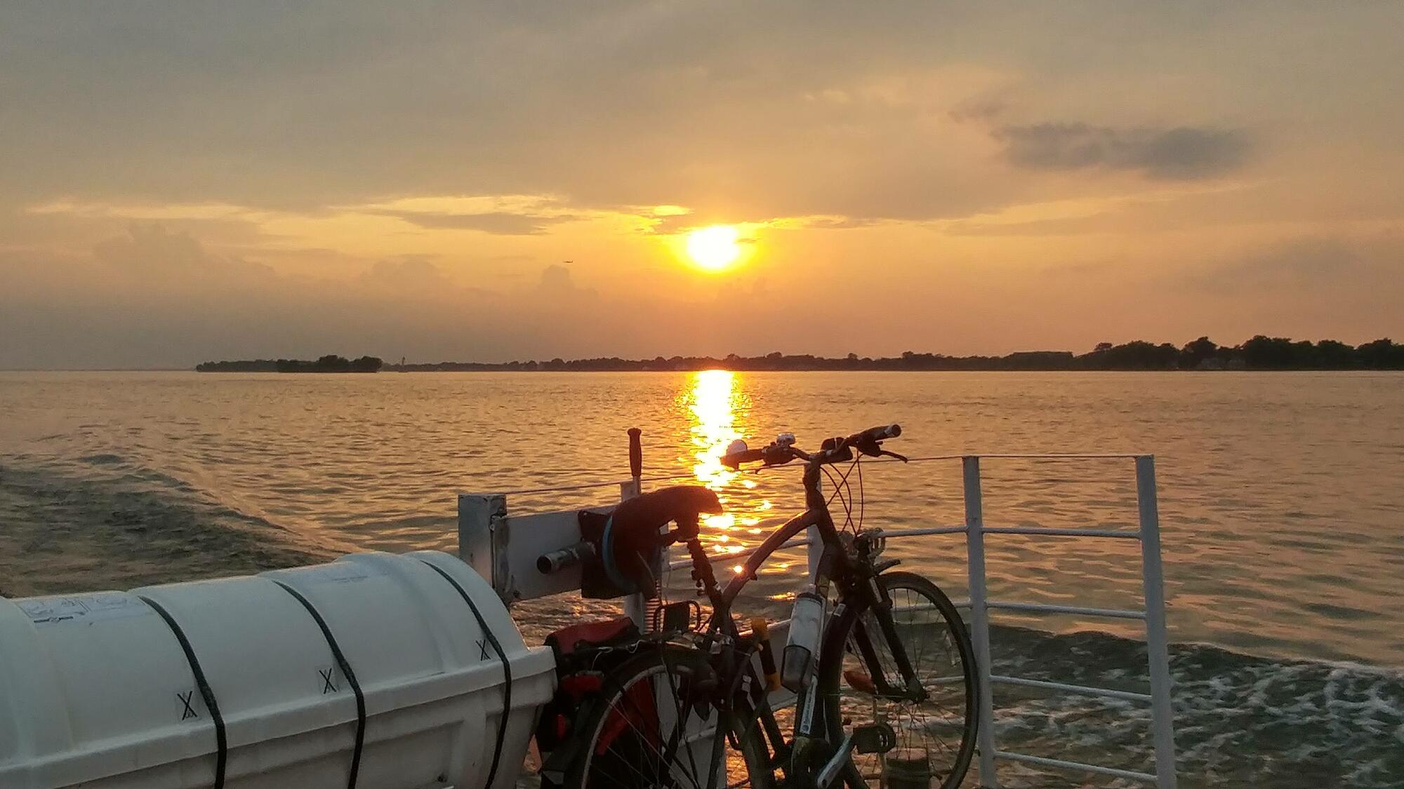 coucher de soleil sur un lac et vélo sur une navette fluviale